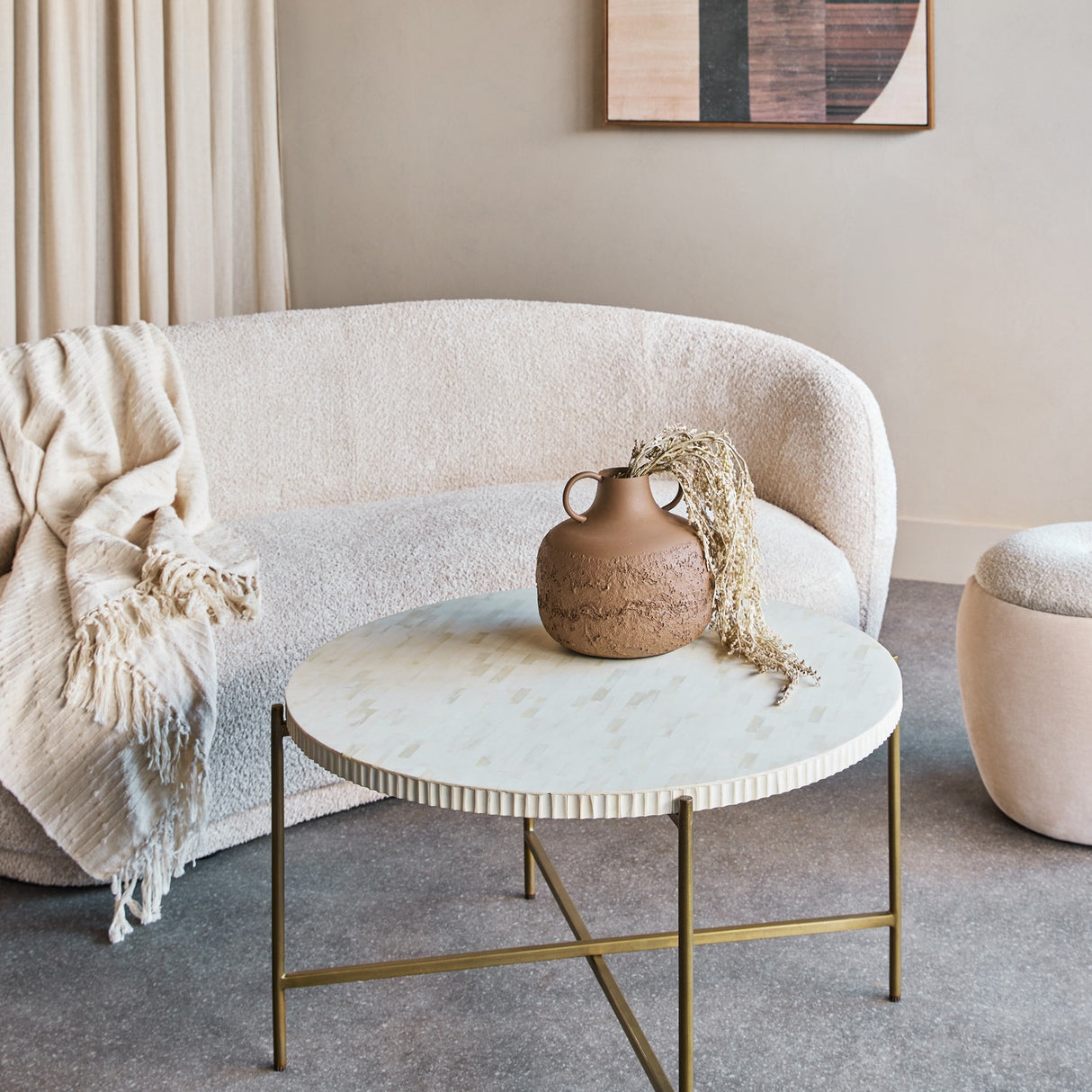 Libra Interiors Bone Inlay Round Brass Coffee Table in white with fluted edge and gold legs, styled in a neutral living room with bouclé sofa and vase.