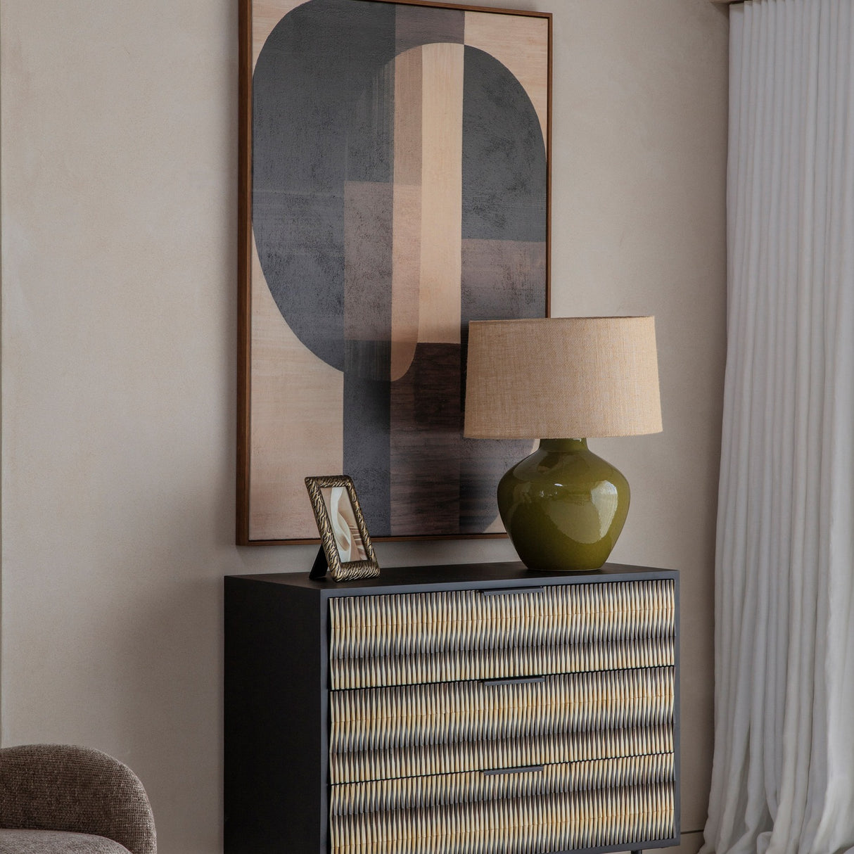Libra Interiors Bone Inlay 3-Drawer Chest styled in a living room with a green table lamp, framed photo and abstract wall art above.