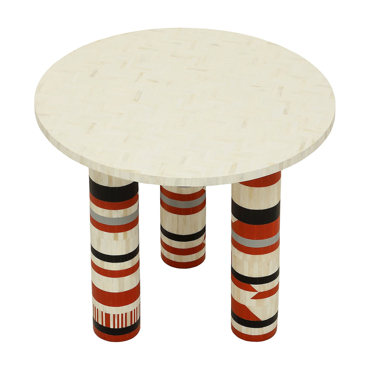 Libra Interiors Bone Inlay Round Dining Table with cream herringbone top and three cylindrical legs in terracotta, black, ivory and grey stripes.