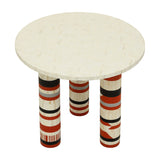 Libra Interiors Bone Inlay Round Dining Table with cream herringbone top and three cylindrical legs in terracotta, black, ivory and grey stripes.