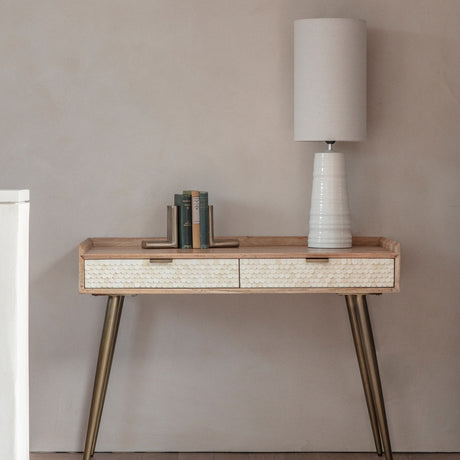 Libra Interiors Scalloped Bone Inlay Mango Wood Desk in cream styled with a white lamp, books and bookends against a neutral wall.