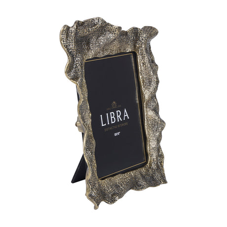Libra Interiors woven-effect cast aluminium 8x10" portrait photo frame in antique brass with rippled organic edges and fold-out stand, on a white background.