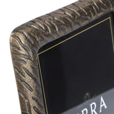 Close-up of the corner of Libra Interiors Etched Cast Aluminium Photo Frame in antique brass, showing the tactile tiger-stripe etching and rounded edge.