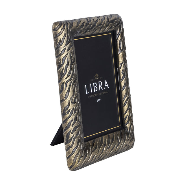 Libra Interiors Etched Tiger cast aluminium 5x7" photo frame in antique brass with textured tiger-stripe border and rear stand for portrait display.