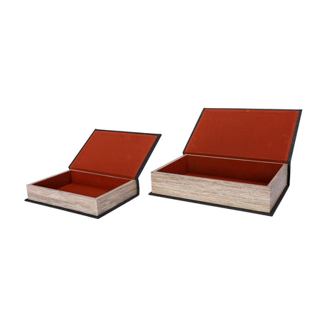 Libra Interiors book-style storage boxes in black linen with wood page-edge sides, hinged lids open to reveal russet velvet linings, on a white background.