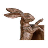 Close-up of Libra Interiors Rustic Weathered Standing Hare Bookend in brown resin, showing sculpted ears, face and paws pressed against the backing plate.