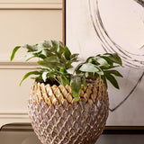 Libra Interiors Scale-Textured Ceramic Planter in brown, holding leafy foliage on a console beside abstract framed art and cream panelling.