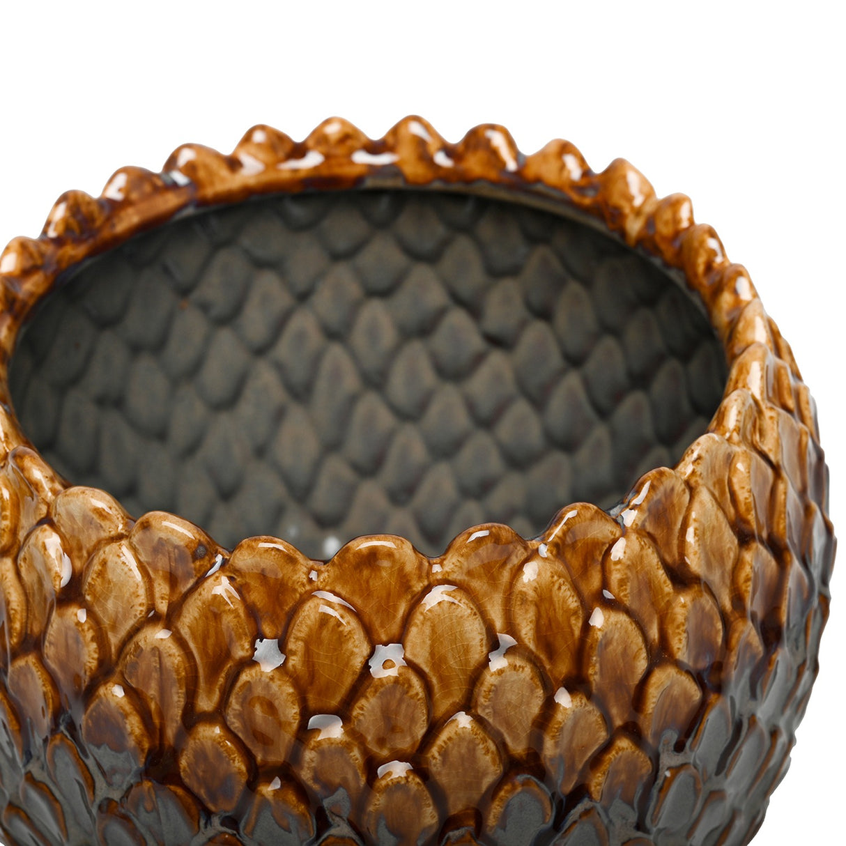 Close-up of Libra Interiors Scale-Textured Ceramic Planter showing glossy amber scales along the rim and grey glazed interior with moulded scale pattern.
