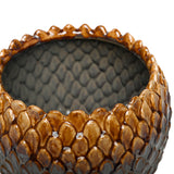 Close-up of Libra Interiors Scale-Textured Ceramic Planter showing glossy amber scales along the rim and grey glazed interior with moulded scale pattern.