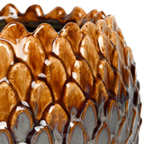 Close-up of Libra Interiors Scale-Textured Ceramic Planter in brown, showing the glossy overlapping scale surface shifting from warm amber to charcoal grey.