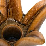 Close-up of Libra Interiors Petal Reactive Glaze ceramic candle holder in brown, showing speckled glossy petals and the recessed centre for a dinner candle.