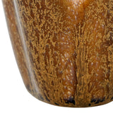 Close-up of Libra Interiors Petal Reactive Glaze ceramic candle holder in brown, showing glossy speckled amber and darker tones across the ridged petal surface.