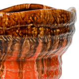 Close-up of the Libra Interiors Reactive Glaze Ceramic Planter in orange, showing the glossy drip glaze pooling from amber and brown into warm terracotta.