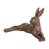 Libra Interiors Rustic Lying Hare resin sculpture in weathered brown, stretched out with front legs extended and ears upright, on a plain white background.