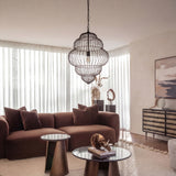 Libra Interiors Tiered Cloud Wire matt black pendant light with layered open-cage iron frame above a brown sofa and round coffee tables in a living room.