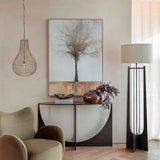 Libra Interiors Burnished Brass Wire Pear Drop Pendant Light hanging beside a curved console table, framed tree artwork, floor lamp and green armchair.