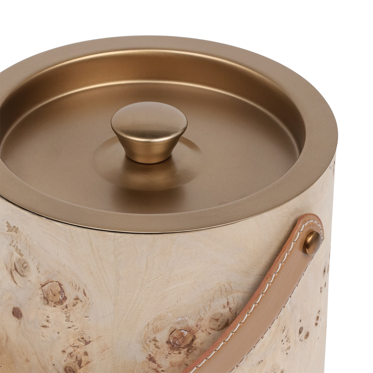 Close-up of the Libra Interiors burlwood veneer ice bucket showing the burnished brass lid with shaped knob and tan leather handle on brass fixings.