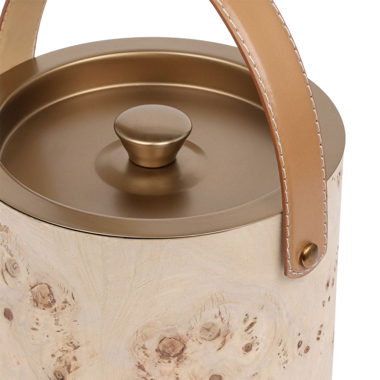 Close-up of Libra Interiors burlwood veneer ice bucket showing burnished brass lid with shaped knob and tan leather handle on brass fixings.