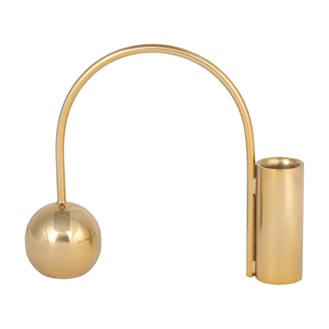 Libra Interiors Arch Gold Taper Candle Holder in polished iron, with a curved arch linking a spherical counterweight to a cylindrical cup, on white.