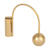 Libra Interiors Arch Gold Taper Candle Holder in polished iron, with a curved arch linking a cylindrical cup to a spherical counterweight, on white.