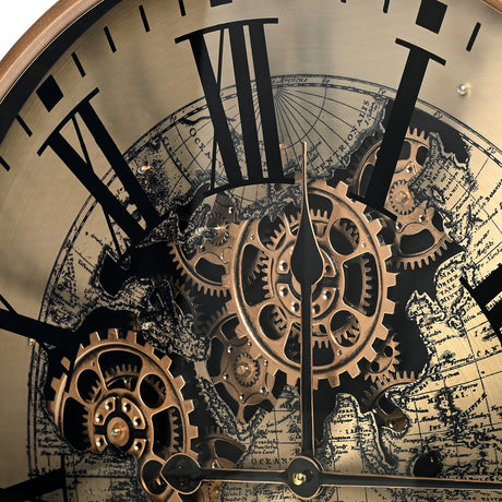 Close-up of Libra Interiors Moving Cogs World Map Wall Clock in antique gold, showing black Roman numerals, exposed brass cogs and sepia map detailing.