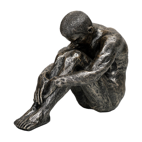 Libra Interiors Textured Resin Seated Male Sculpture in antique gold, figure with head bowed onto folded arms and knees drawn in, on a white background.