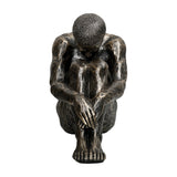 Libra Interiors textured resin seated male sculpture in antique gold, shown from the front with head bowed onto folded arms and knees drawn in close.
