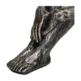 Close-up of the folded arm, hand and foot on the Libra Interiors Textured Resin Seated Male Sculpture in antique gold.