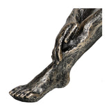 Close-up of the Libra Interiors Textured Resin Seated Female Sculpture in antique gold, showing the outstretched leg, foot and resting hand in detail.