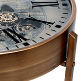Close-up of Libra Interiors Clock Top Round Antique Gold Side Table showing the glass top, Roman numerals, exposed cogs and brushed smoked gold frame.
