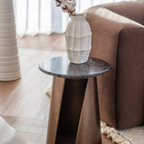 Libra Interiors Marble Top Smoked Gold Side Table with round black marble top and angular gold iron base, styled beside a brown leather sofa with a white vase.