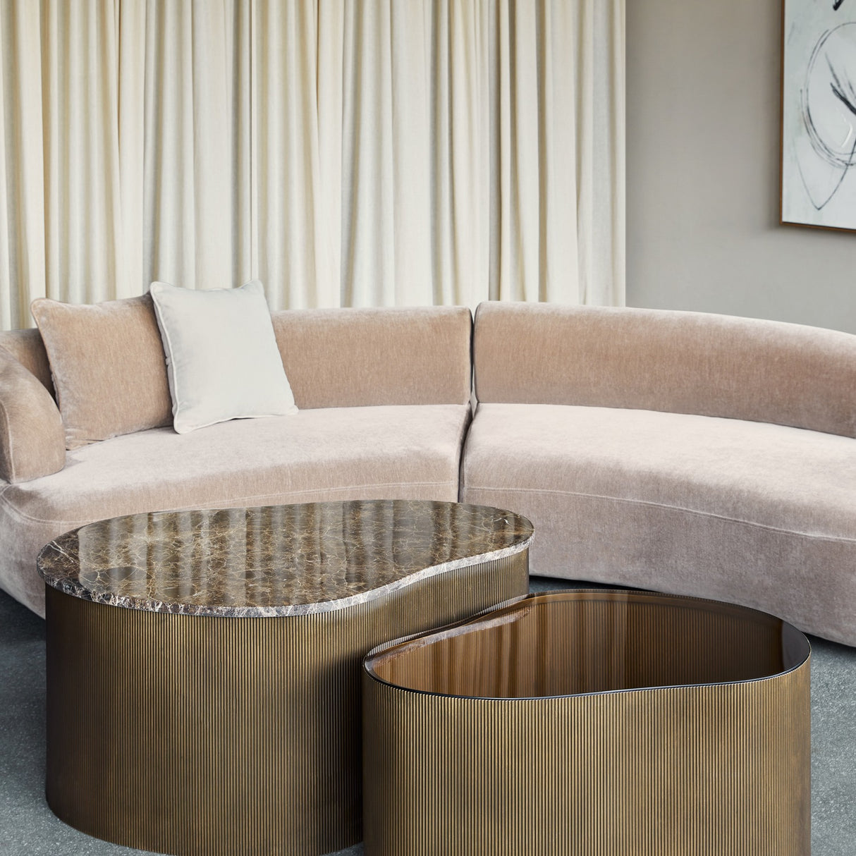 Libra Interiors Marble & Glass nesting coffee tables with organic shapes, brown Emperador marble and tinted glass tops on burnished gold corrugated bases.