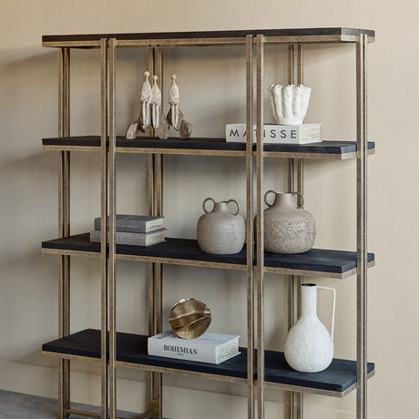 Libra Interiors Sandblasted Mango Wood Champagne Gold Wall Shelf styled with ceramic vases, books and sculptures across four black tiers in a neutral room.