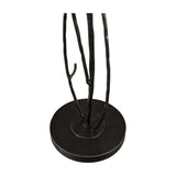 Close-up of the Libra Interiors Branch Iron Blackened Floor Lamp base, showing hand-forged iron branch stems rising from a round blackened metal foot.