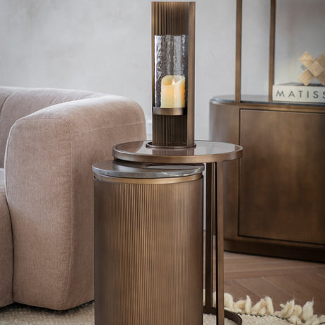 Libra Interiors Marble & Glass Nesting Side Tables in gold with fluted smoked metal frames, tinted glass and marble tops, styled beside a beige sofa.