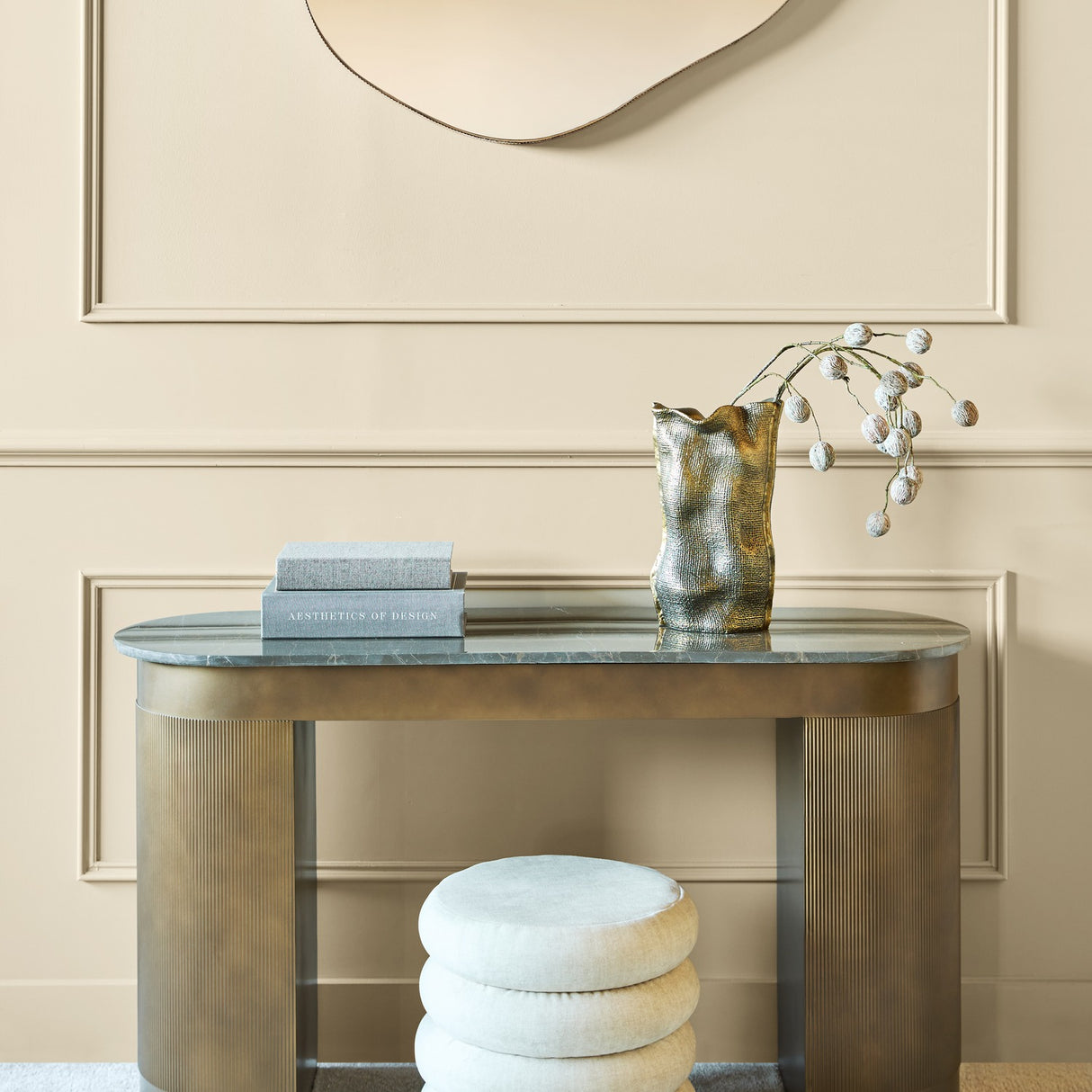 Libra Interiors Fluted Marble Top Pedestal Desk in gold with smoked grey marble top, styled with books and a gold vase in a panelled hallway.