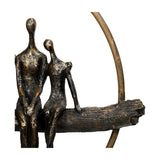 Close-up of Libra Interiors Rough Cast Four Figure Circle Family Sculpture showing two bronze figures seated on a textured branch within a curved ring.