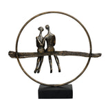Libra Interiors Antique Gold Circle Seated Couple Sculpture with two resin figures on a textured branch inside a metallic ring on a black base.