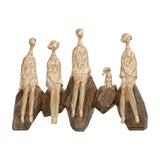 Libra Interiors Carved Resin Figural Family Sculpture in brown, four elongated figures and a small dog seated on angular rock forms, on a white background.