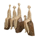 Libra Interiors Carved Resin Figural Family Sculpture in brown, showing five elongated stylised figures and a small dog seated across angular rock forms.