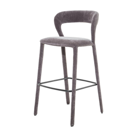 Libra Interiors grey velvet curved-back bar stool with low backrest, upholstered legs and black powder-coated steel footrest on a white background.