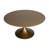 Libra Interiors Brushed Brass Pedestal Round Dining Table with a bevelled wood-grain top and flared antique brass column base, on a white background.