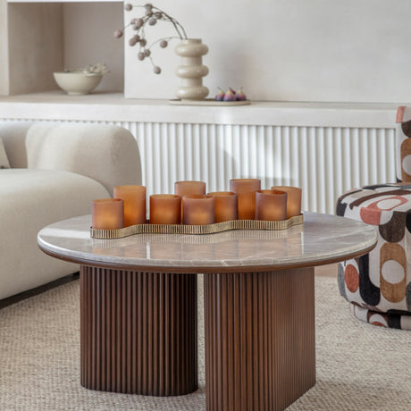 Libra Interiors Marble Top Fluted Walnut Round Coffee Table with pebble grey top and twin fluted pedestals, styled with amber votives in a living room.