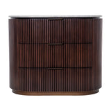 Libra Interiors Fluted Walnut Marble-Top Chest of Drawers in brown with three drawers, antique brass handles and pebble grey marble top on a plain background.