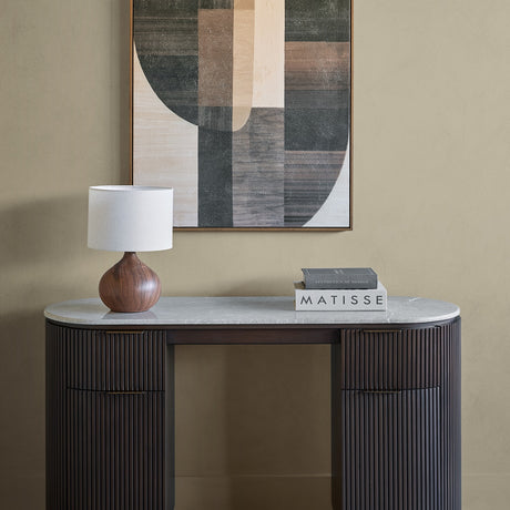 Libra Interiors Marble Top Fluted Walnut Pedestal Desk in brown styled with a wooden lamp and Matisse books beneath a geometric artwork.