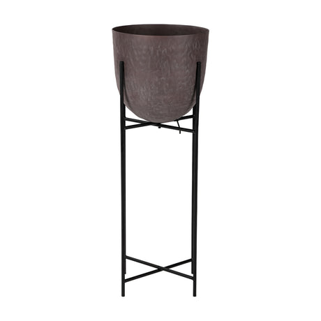 Libra Interiors Hammered Aluminium Raised Planter in brown, a curved matt stonewash pot set on a tall slim black iron four-leg stand, on a white background.