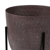 Libra Interiors Hammered Aluminium Raised Planter in brown with textured stonewash bowl and black iron stand legs on a white background.