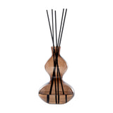 Libra Interiors Sculptural Glass Reed Diffuser in warm brown, curved double-gourd vessel with black reeds, shown against a plain white background.