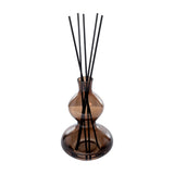 Libra Interiors Sculptural Glass Reed Diffuser in warm brown with a curved double-gourd vessel and tall black reeds, shown on a white background.