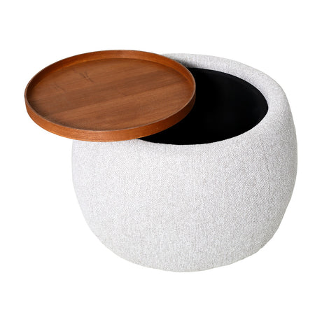 Libra Interiors cream chenille storage ottoman with round padded base and lifted walnut veneer tray top revealing black interior storage.